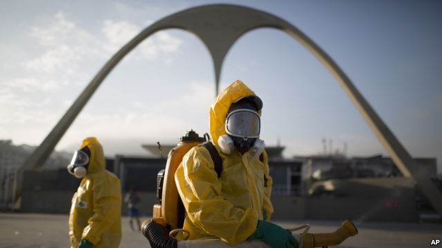 FILE - Health workers spray insecticide in the Sambadrone to combat the Aedes aegypti mosquito that transmits the Zika virus, in Rio de Janeiro, Brazil, Jan. 26, 2016. The Sambadrome will be among the venues at this year's Summer Games in Rio.