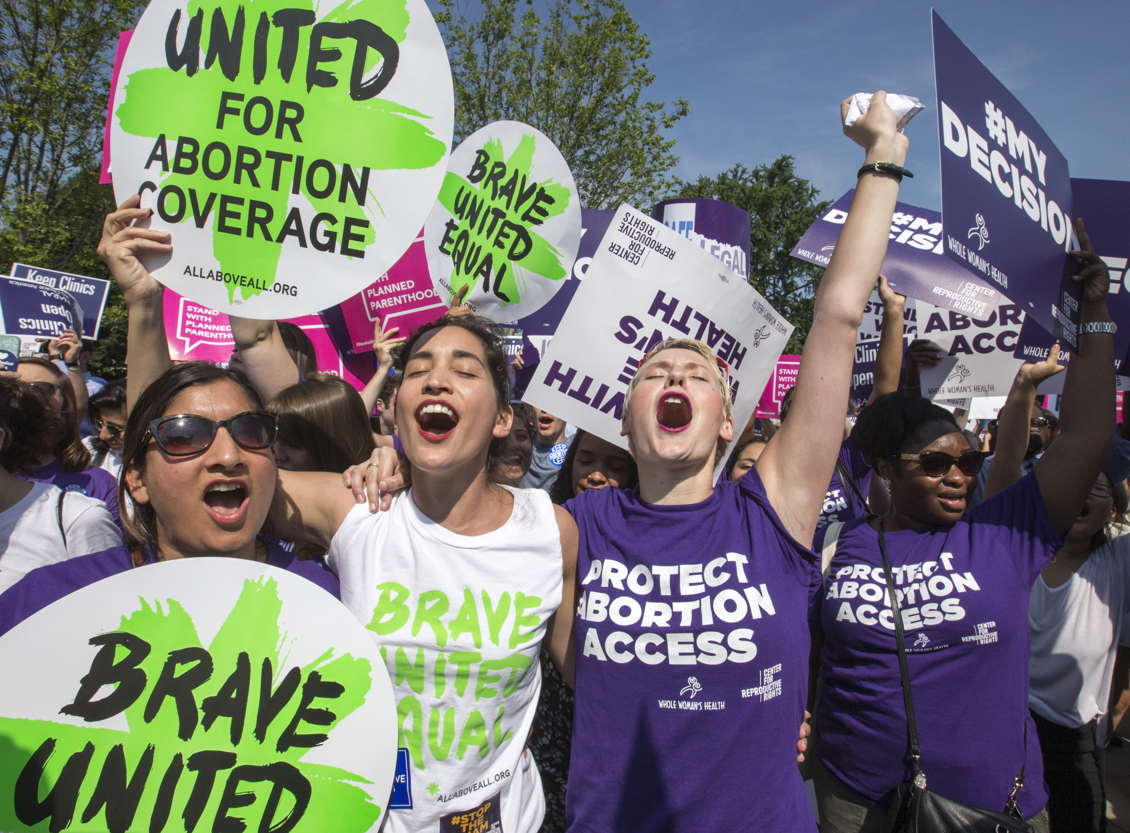 Abortion rights activists, from left, Ravina Daphtary of Philadelphia, Morgan Hopkins of Boston, and Alison Turkos of New York City, rejoice in front of the Supreme Court in Washington, Monday, June 27, 2016, as the justices struck down the strict Texas anti-abortion restriction law known as HB2. (AP) 