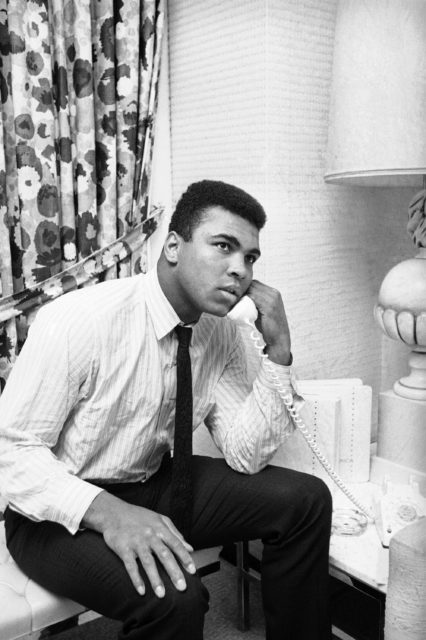 World heavyweight champion Muhammad Ali chats on the phone with a friend in his room on his arrival in Houston, Feb. 20, 1967. The champ was silent on his thoughts about his draft status referring all questions to his New York attorney. (AP)