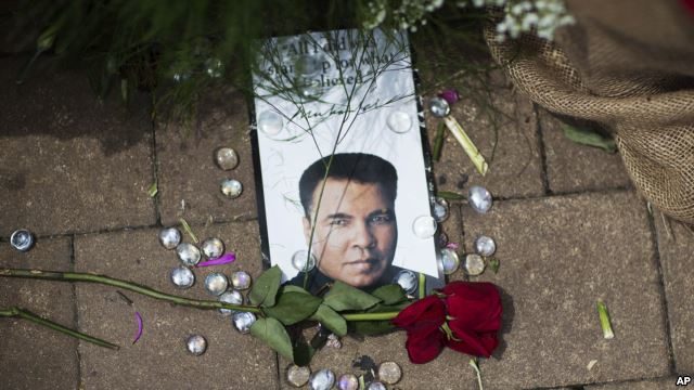 A rose lays next to an image of Muhammad Ali at a makeshift memorial at the Muhammad Ali Center, June 5, 2016, in Louisville, Kentucky. Ali, the heavyweight champion whose fast fists and irrepressible personality transcended sports and captivated the world, die