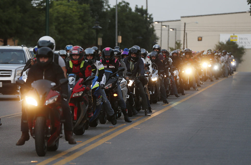 A group of motorcycles, organized by the group Ride DFW, ride past the memorial in front of police headquarters to pay respects in Dallas, Sunday, July 10, 2016. A peaceful protest over the recent videotaped shootings of black men by police turned violent Thursday night as gunman Micah Johnson shot at officers. (AP)