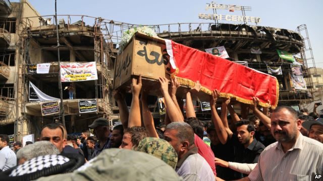 Mourners carry the Iraqi flag-draped coffin of, Akram Hadi, 24, in a Sunday massive truck bomb attack in the Karada neighborhood of Baghdad, Iraq, July 5, 2016. 