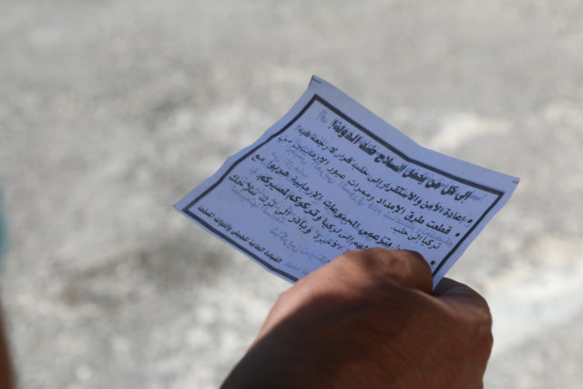 A man holds one of the leaflets dropped by the Syrian army over opposition-held Aleppo districts asking residents to cooperate with the military and calling on fighters to surrender, Syria July 28, 2016. (Reuters) 