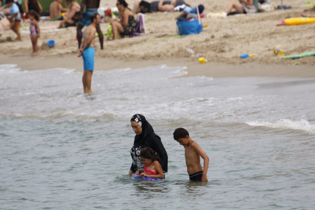 A Muslim woman wears a burkini, a swimsuit that leaves only the face, hands and feet exposed, on a beach in Marseille, France, August 17, 2016. (Reuters) 