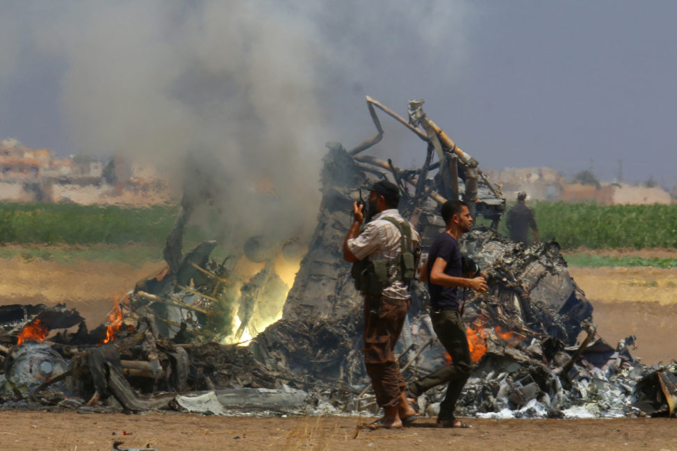 Men inspect the wreckage of a Russian helicopter that had been shot down in the north of Syria's rebel-held Idlib province, Syria August 1, 2016. (Reuters) 