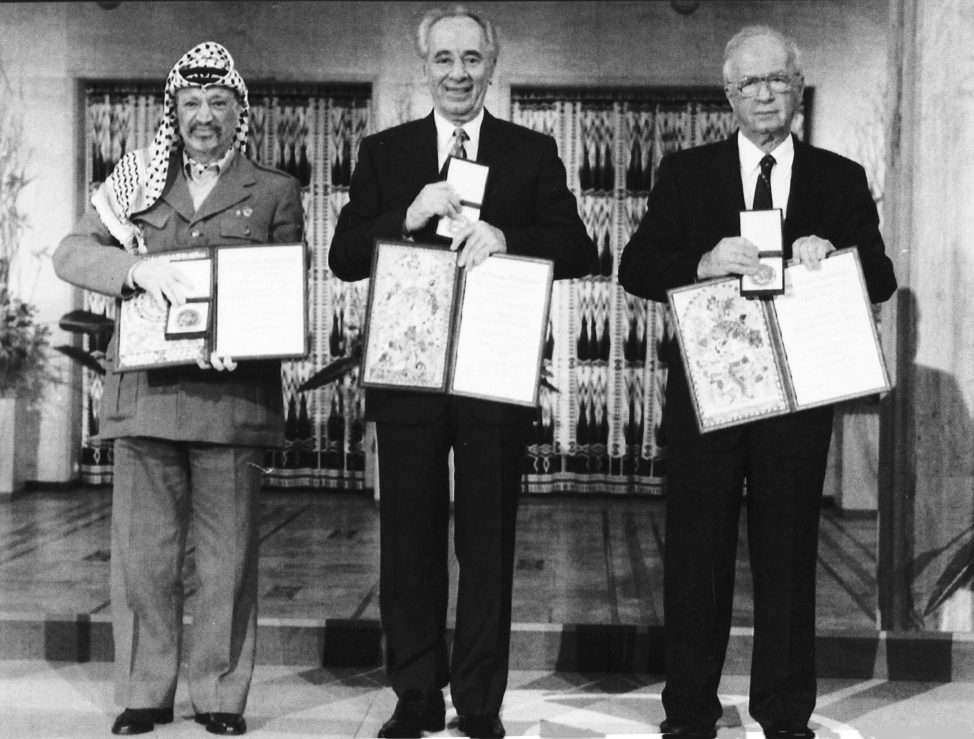 PLO leader Yasser Arafat, left, Israeli Prime Minister Yitzhak Rabin, center, and Israeli Foreign Minister Shimon Peres pose with their medals and diplomas, after receiving the 1994 Nobel Peace Prize in Oslo's City Hall, Dec. 10, 1994. The three men received the prize for their efforts towards peace in the Middle East. (AP)