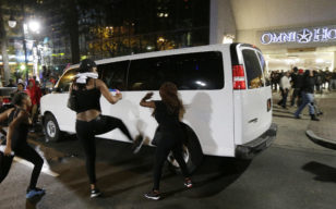 Demonstrators protest Tuesday's fatal police shooting of Keith Lamont Scott in Charlotte, N.C. on Wednesday, Sept. 21, 2016. Protesters rushed police in riot gear at a downtown Charlotte hotel and officers have fired tear gas to disperse the crowd. (AP) 