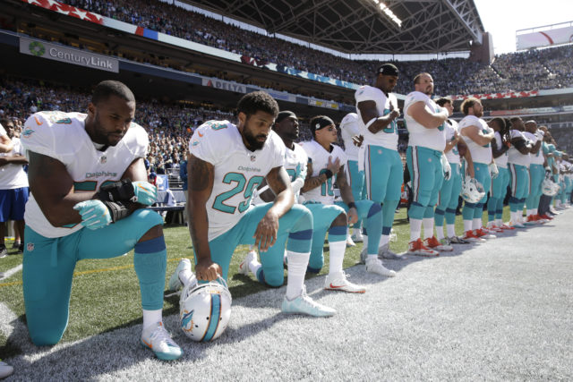 From left, Miami Dolphins' Jelani Jenkins, Arian Foster, Michael Thomas, and Kenny Stills, kneel during the singing of the national anthem before an NFL football game against the Seattle Seahawks, Sept. 11, 2016, in Seattle. (AP) 