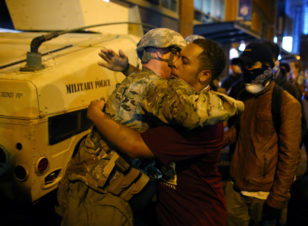 A U.S. National guard soldier accepts a hug from protester as people march through downtown to protest the police shooting of Keith Scott in Charlotte, North Carolina, Sept. 22, 2016. (Reuters) 