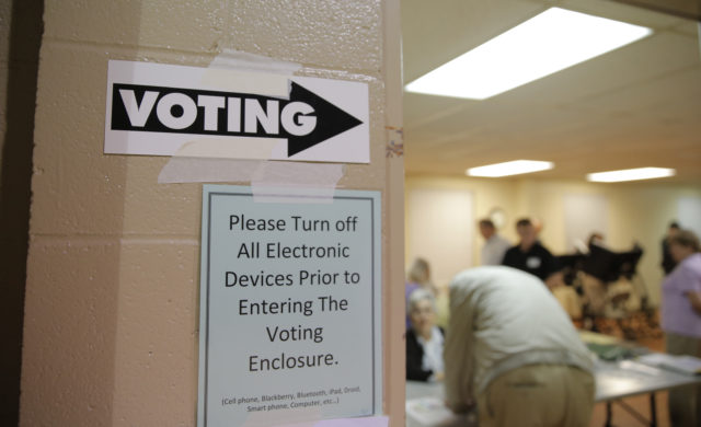 A sign points the way toward the voting booths as voting commences in North Carolina's U.S. presidential primary election at Sharon Presbyterian Church in Charlotte, North Carolina March 15, 2016. (Reuters) 