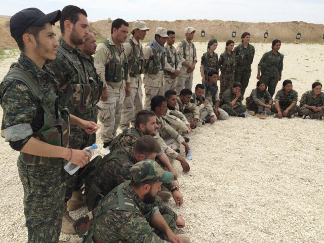 In this file photo taken May 21, 2016, members of what the U.S. calls the Syrian Democratic Forces gather after a training session at a firing range in northern Syria. Simultaneous attacks on the Islamic State-held city of Mosul in Iraq and Raqqa, the de facto IS capital across the border in eastern Syria, would make military sense: They would make it harder for the extremists to move reinforcements and deny them a safe haven. (AP) 