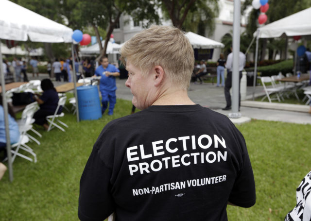 Lisa Hubbard, a volunteer with the non-partisan Election Protection Coalition, attends an early voting celebration outside of Jackson Memorial Hospital, on the first day of early voting in Miami-Dade County for the general election, Oct. 24, 2016, in Miami. The event was organized by local unions and immigrant groups to encourage people to vote during the two week early voting period. (AP)