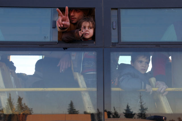 Syrians who were evacuated from rebel-held neighborhoods in Aleppo deliver a hopeful gesture as they arrive in the opposition-controlled Khan al-Aassal region, west of the city, Dec. 15, 2016. Hundreds of civilians and rebels left Aleppo under an evacuation deal that will allow Syria's regime to take full control of the city after years of fighting. (AFP)